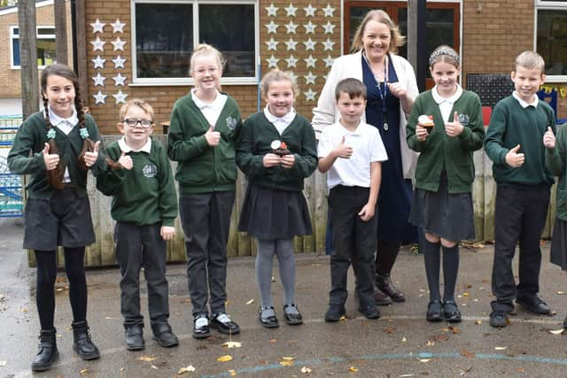 Pupils celebrate outside their school with headteacher Vicki Hardwick.