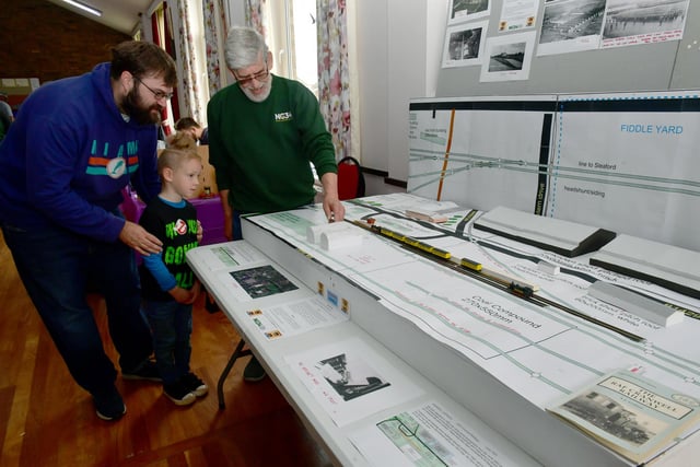 Gareth Evans and Wyatt Evans, six, of Sleaford with club secretary Colin Houseman, with a representation of RAF Cranwell station.