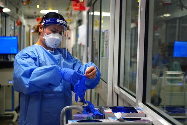 File photo dated 21/12/2021 of a nurse puts on PPE in a ward for Covid patients . Unresolved disputes between the Government and suppliers of poor quality personal protective equipment (PPE) could cost the taxpayer £2.7 billion, MPs have warned. "Significant failings" by the Department of Health and Social Care (DHSC) in handling PPE contracts during the pandemic have also led to a surplus of four billion unneeded items, some of which will be burned, according to a new report by the Public Accounts Committee (PAC). Issue date: Wednesday July 20, 2022.