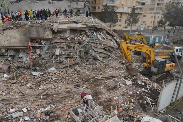 Rescue personnel search for victims and survivors through the rubble of buildings in Kahramanmaras, the day after a 7.8-magnitude earthquake struck the country's southeast, on February 7, 2023. (Photo by ILYAS AKENGIN/AFP via Getty Images)