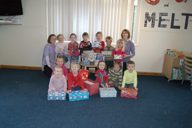Families of children at Whitegate Kindergarten, in Caistor, donated more than 30 shoeboxes of items for Operation Christmas Child 10 years ago. Pictured are Kindergarten proprietor Angela Lawrence (right) and Bethany Tutty (child care apprentice) with the children and the boxes.