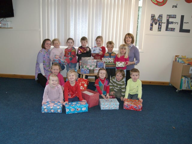 Families of children at Whitegate Kindergarten, in Caistor, donated more than 30 shoeboxes of items for Operation Christmas Child 10 years ago. Pictured are Kindergarten proprietor Angela Lawrence (right) and Bethany Tutty (child care apprentice) with the children and the boxes.
