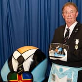 Freemason Rob Lang with his award, a facsimile of the larger one behind him, which was created as part of a street art project in Lincoln to promote Freemasonry to the wider world.