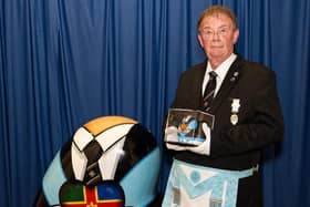 Freemason Rob Lang with his award, a facsimile of the larger one behind him, which was created as part of a street art project in Lincoln to promote Freemasonry to the wider world.