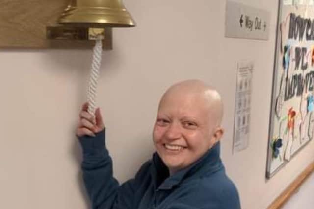 Michelle celebrating her remission from cancer by ringing the bell.