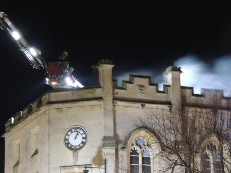 Firefighters on the aerial ladder platform hose down the roof of the old sessions house in Sleaford. Photo: Andy Hubbert