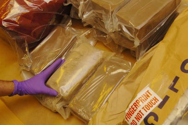 A member of staff at the Forensic Science Service in London examines part of a 33 kg haul of heroin seized by the Metropolitan Police. The heroin is being examined to aid police officers in their investigation surrounding the haul.