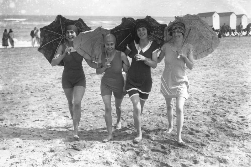 Four bathing belles shading themselves with parasols on the beach at Skegness in 1926.