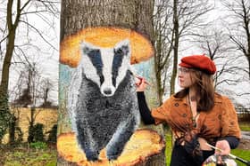 Mural artist Nikita Spires with her badger mural on Eastfield Road.