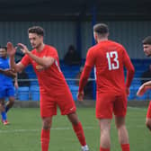 Joe Smith (centre) is congratulated after netting Sleaford's winner. Photo: Ollie Atkin.