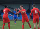 Joe Smith (centre) is congratulated after netting Sleaford's winner. Photo: Ollie Atkin.