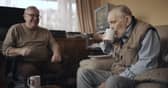 Volunteer Liam (left) with blind veteran Ken enjoying a cup of tea and a chat