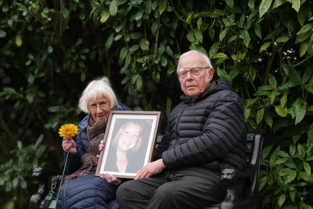 Martin and Elaine with a photo of their daughter, Christine, on her memorial bench.