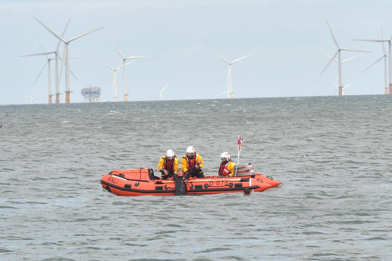 The RNLI D-class  inshore lifeboat crew demonstates a rescue with the help of lifeguards.