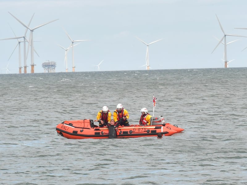 The RNLI D-class inshore lifeboat crew demonstates a rescue with the help of lifeguards.