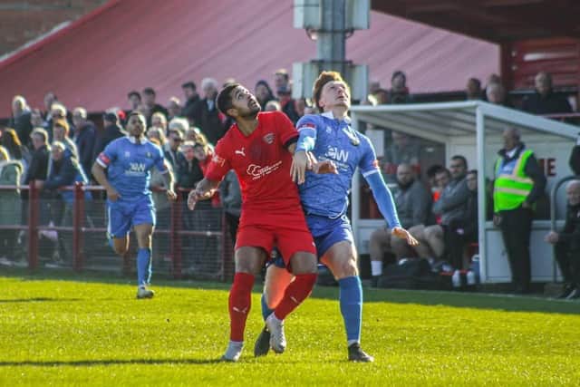 Will Lancaster (blue) battles for the ball against Workington's Jamie Allen