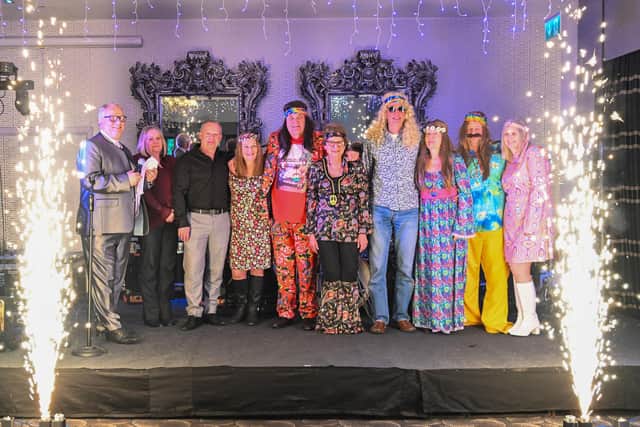 Managing director Peter Atterby, left, with some of the staff at a Sixties themed celebration held in Louth this month to mark 60 years in business. Image rights - Orange In The Wild