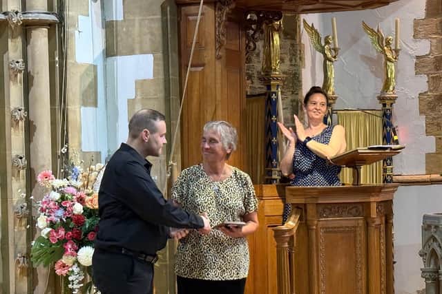 Rotary President Tamara Good is presented with a commemorative shield by a choir member