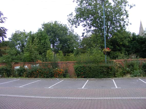 The overgrown garden behind the wall of Money's Yard car park, set to become a new riverside park in the town centre.