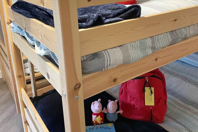 A example of a bed set up for a child at Boston Women's Aid, with a bag donated by the Buddy Bag Foundation filled with pyjamas, books, teddies, toiletries and more.
