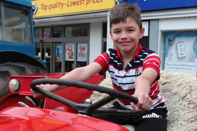 Logan Woodrow gets behind the wheel of a 1972 Massey Ferguson tractor.