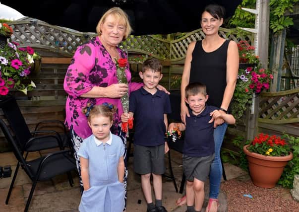 Guardian Rose presentation to Linda Silk, pictured receiving her rose from Louise Baxendale and children Harry, eight, Molly, three and George, five