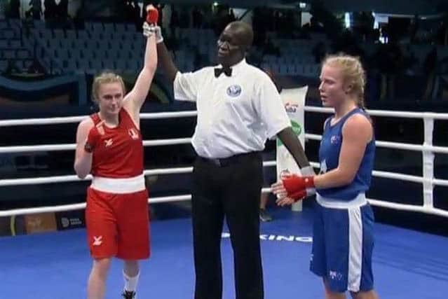 The referee holds aloft the arm of Gemma Richardson to signal her victory.