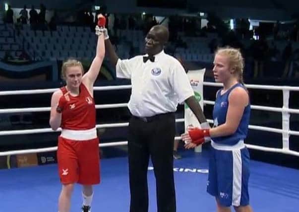 The referee holds aloft the arm of Gemma Richardson to signal her victory.