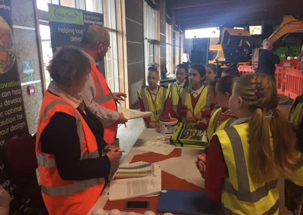 Schoolchildren gathering around one of the stands at the Construction Week event.