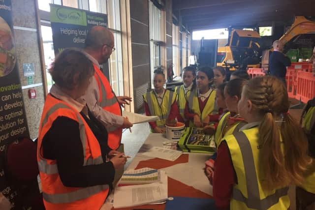 Schoolchildren gathering around one of the stands at the Construction Week event.