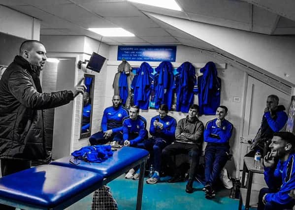 A scene from the video as songwriter Ben Spurr raps to Trinity players in the dressing room.