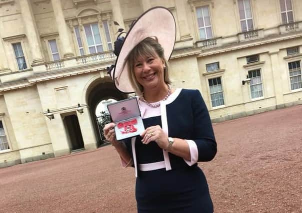 Anne-Maria Newham with her MBE at Buckingham Palace.