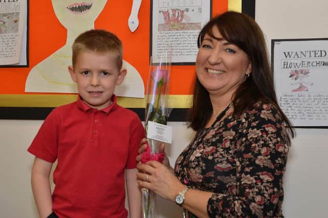 Guardian Rose presentation to Redlands Primary School teaching assistant Liane Tuke from pupil Ethan Myers, six