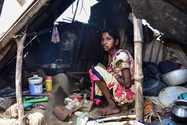 A survivor huddles under a makeshift shelter after Cyclone Fani had ravaged her home. (PHOTO BY: Asit Kumar/AFP/Getty Images).