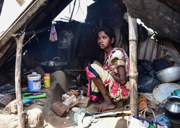 A survivor huddles under a makeshift shelter after Cyclone Fani had ravaged her home. (PHOTO BY: Asit Kumar/AFP/Getty Images).
