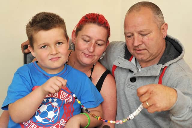 The family of nine-year-old Bailey Hancock who has leukaemia are fundraising to raise money towards a special holiday. Pictured are Bailey Hancock, nine with Dad Steve and Mum Lisa looking at his Beads of Courage, given to him by Sheffield Children's Hospital (w121009-11b)