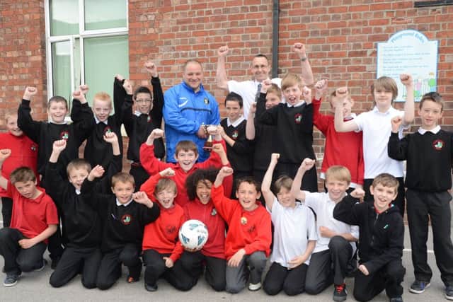 Gainsborough Trinity manager Steve Housham presents Parish Church Primary School with the Primarys Schools League Winners Trophy G130427-6