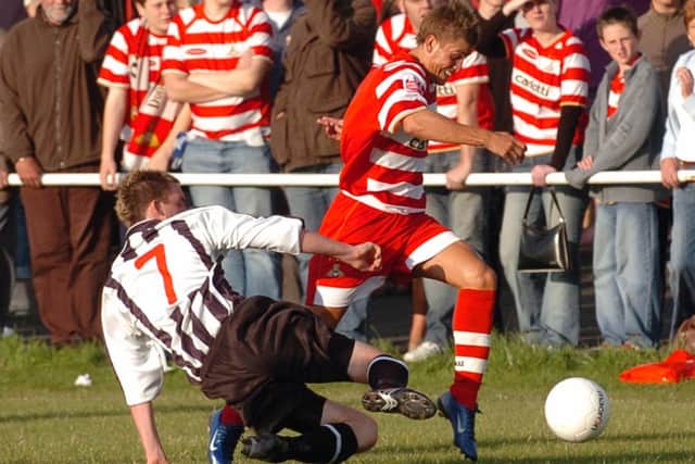 Doncaster Rovers' Craig Nelthorpe on the attack against Retford United's Lee Holmes. (Picture: CHRIS BULL D5095CB)