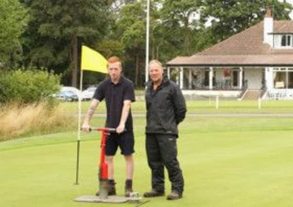 Apprentice Aaron Stern learns the ropes from head green keeper Adrian Kitchinson