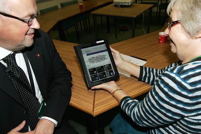 Steve Brown shows Sylvia May the use of the new website on a tablet