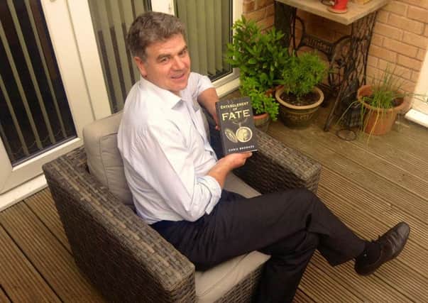 Local author Chris Brookes with a copy of his new book, Entanglement of Fate