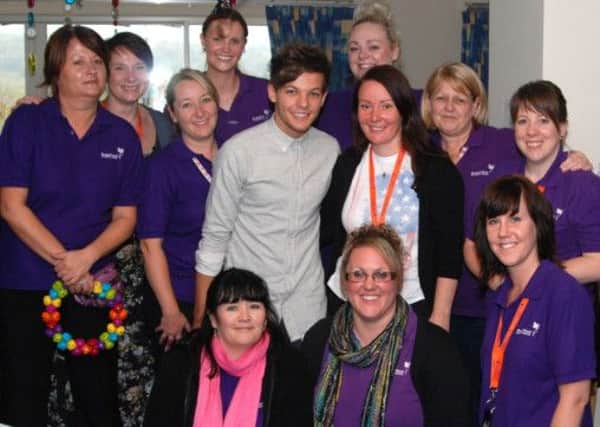 One diorection's Louis Tomlinson with staff from Bluebell Wood Hospice.