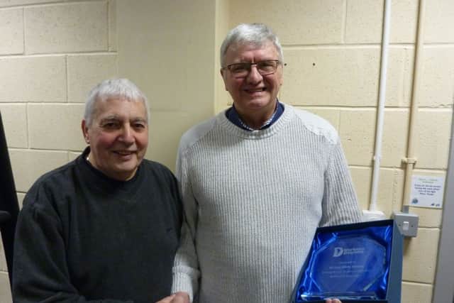 Alex McLauchlan, left, presents Mike Conroy with a trophy to mark his 33 years service