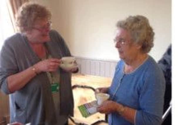 Jeannette Walker (left) discusses recycling issues with Sheila Laycock over a traditional WI cup of tea