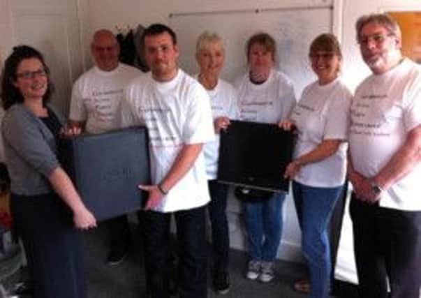 Annie Sawyer handing over the computer to Andy Fox at the Foundry Learning Centre. Also in the picture (L-R) are Mick Thrower, Sue Holtby, Angela Thornton, Kim Basu and Paul Roberts.