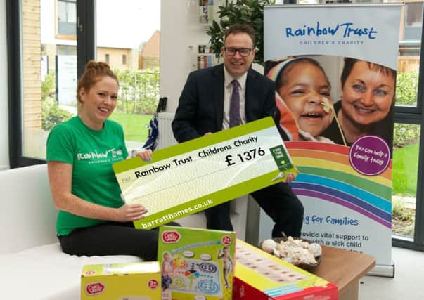 David Waddington, sales operations manager with Barratt, presents the chque to a Rainbow Trust representative