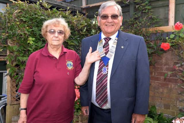 Outgoing president Audrey Agnew hands over the chains of office to Lion Bill Maddison