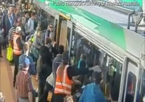 PASSENGERS TEAM UP TO TILT TRAIN OFF TRAPPED MAN IN AUSTRALIA