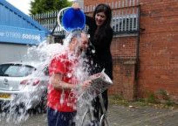 Guardian reporter John Smith gets a bucket of icy water poured over him by fellow reporter Sophie Wills as part of the Ice Bucket Challenge