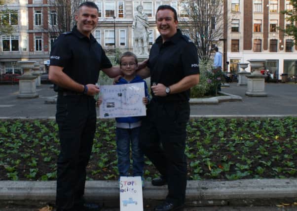 Jayden Prestwood with PC Jon Peacock and PC Rich Precious and the game he invented.